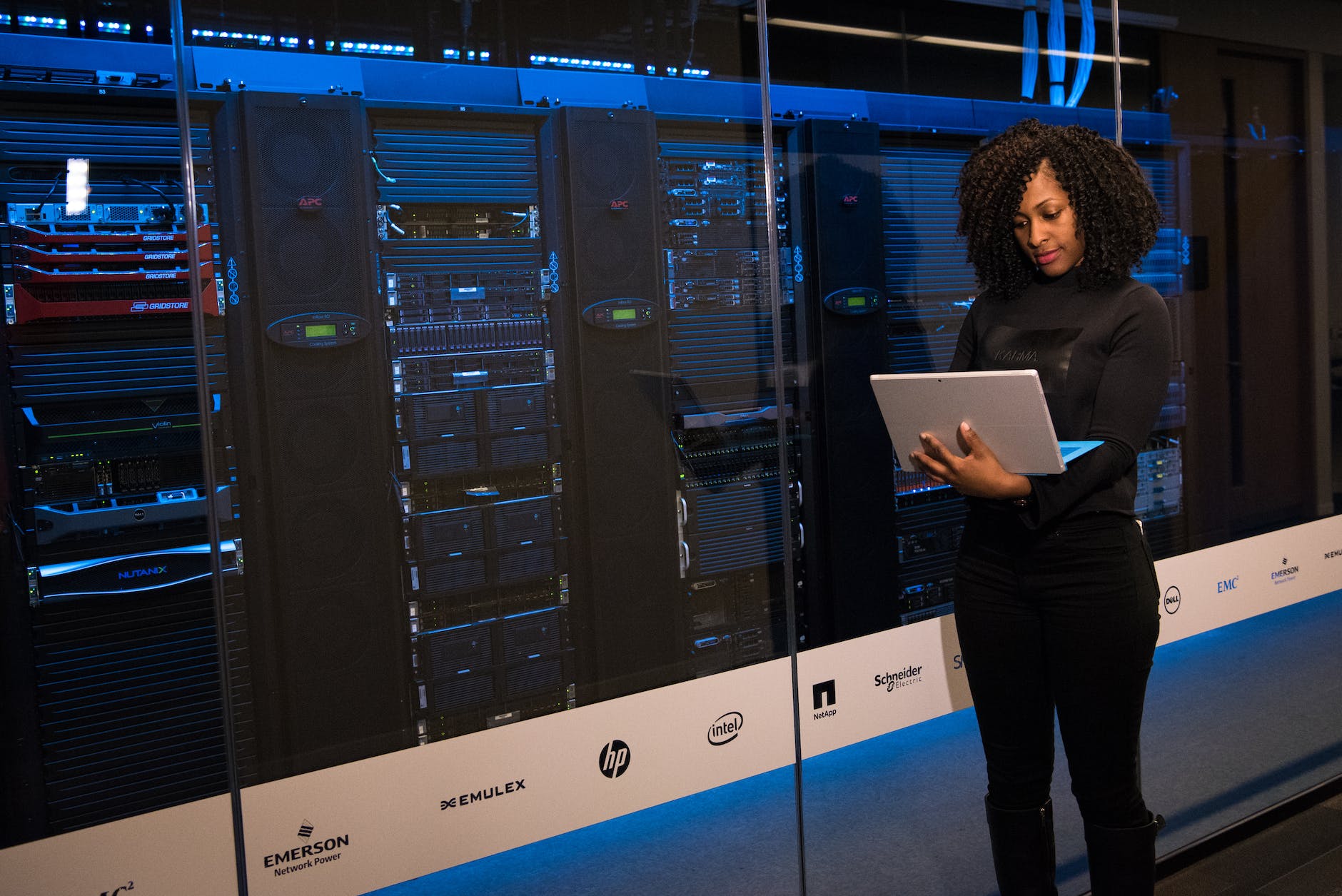 data scientist working with AI standing next to server racks