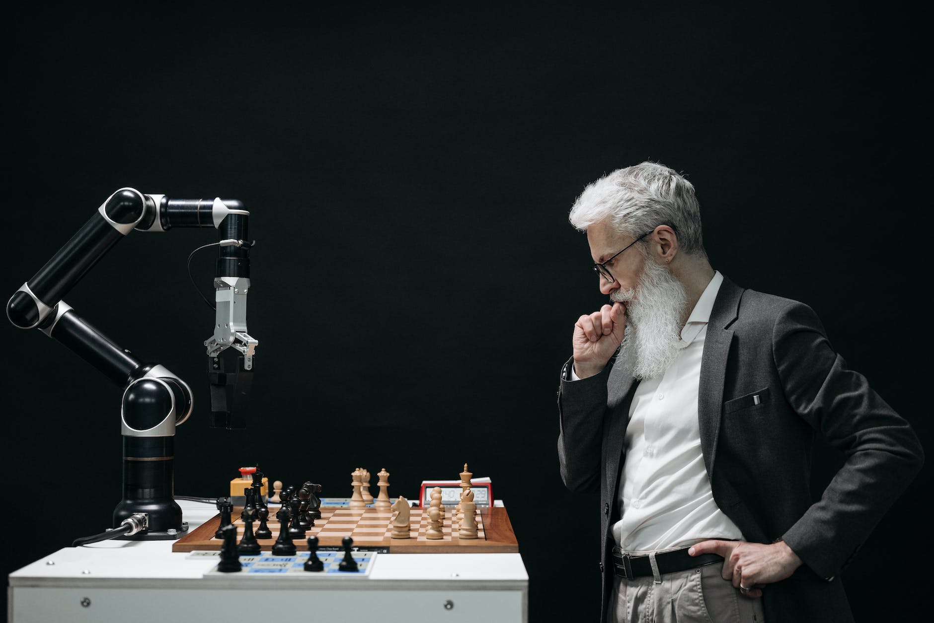 elderly man looking at a chess board across from an artificial intelligence robot