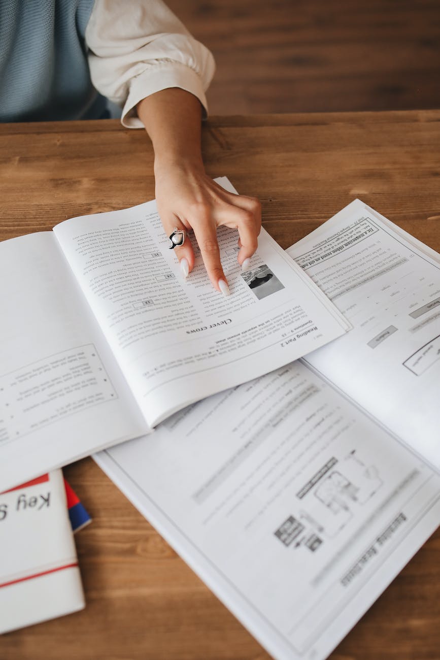 persons hand on a book studying the material