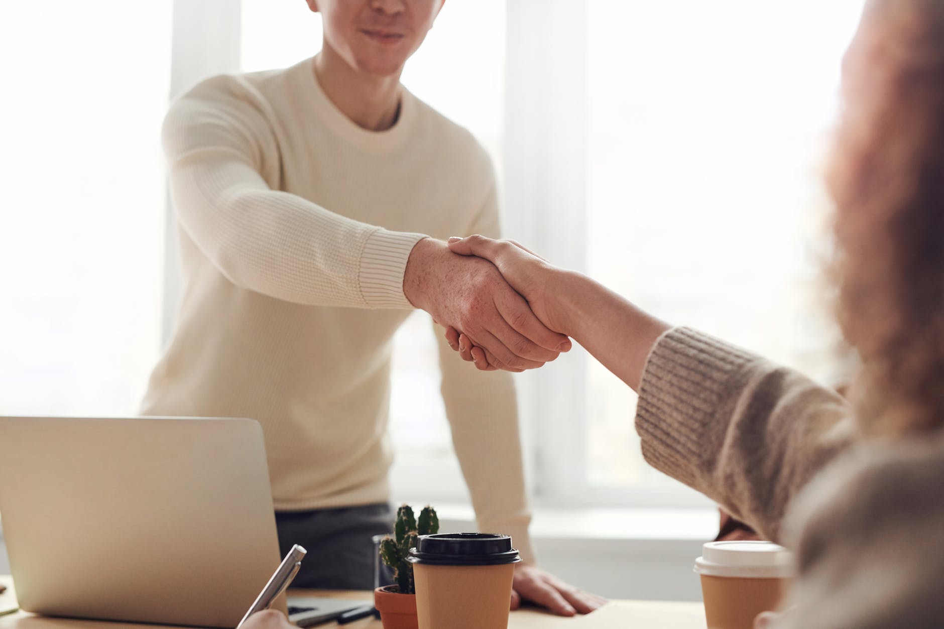IT hiring manager shaking job candidate's hand